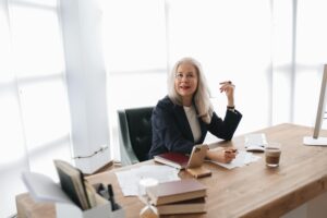 Persona trabajando en laptop con silla ejecutiva ergonómica
